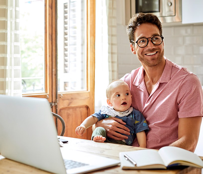 Un jeune pre tient son nourrisson tout en tudiant